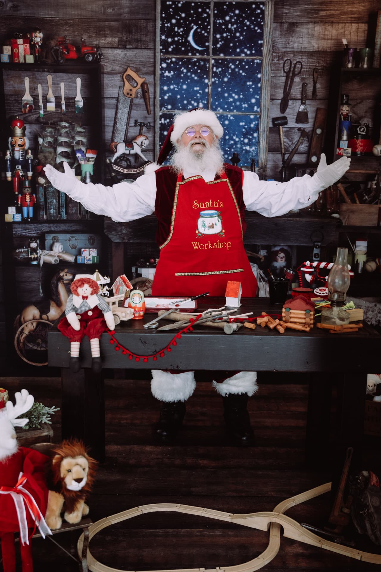 Santa welcoming families with open arms at his workshop bench
