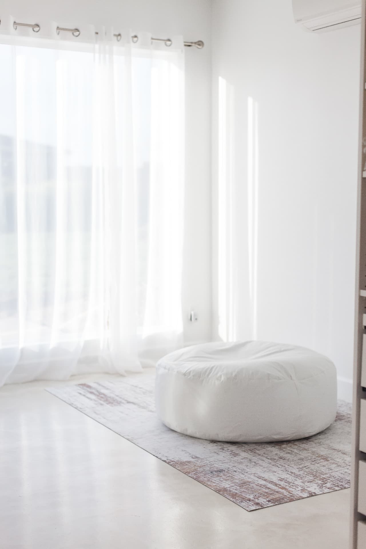 Sheer curtains and oversized bean bag on a vintage rug at Glam Studios