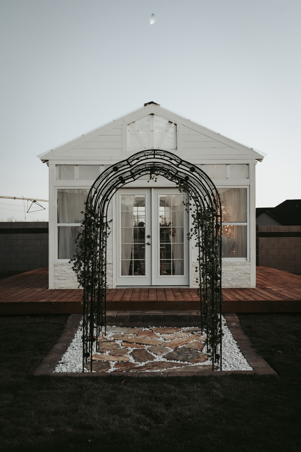 The Glasshouse exterior at dusk with ivy arbor entrance