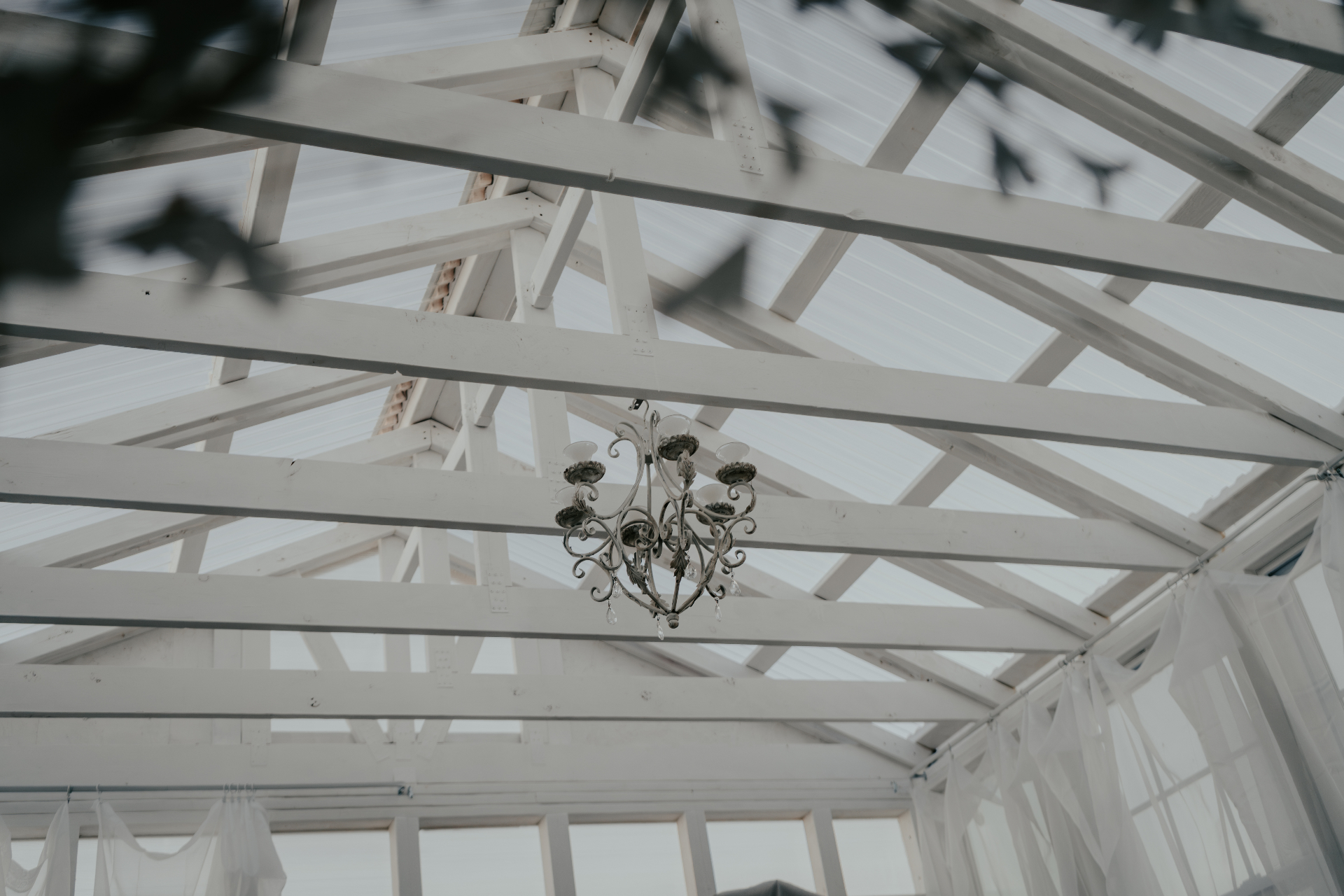 Chandelier detail against white timber trusses