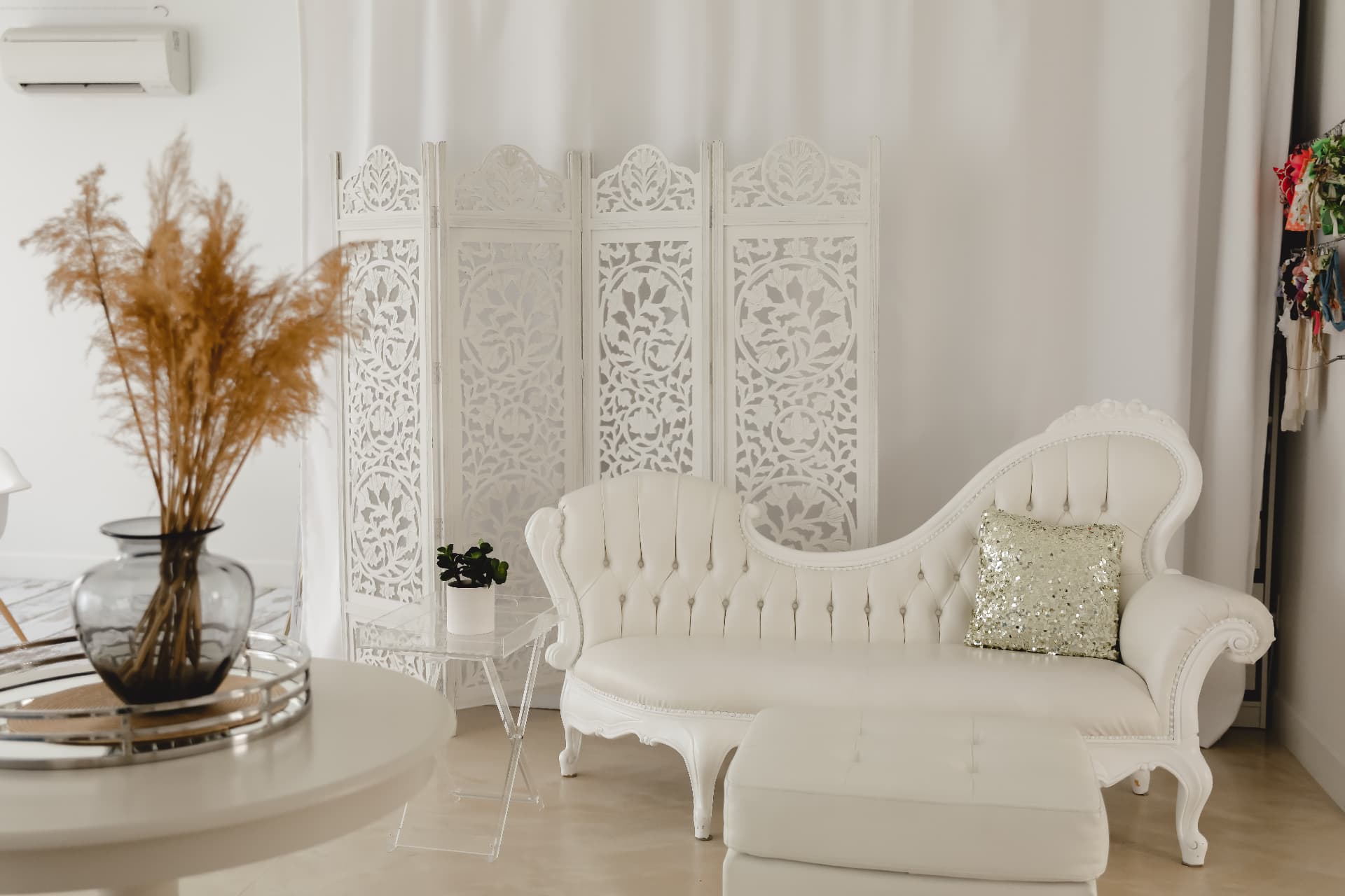 White tufted chaise, carved screen and pampas grass lounge at Glam Studios
