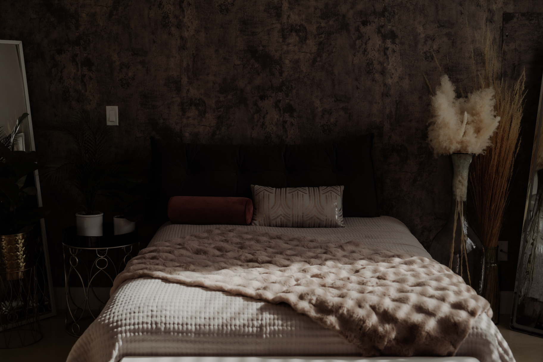 Moody boudoir bed styled with blush throw