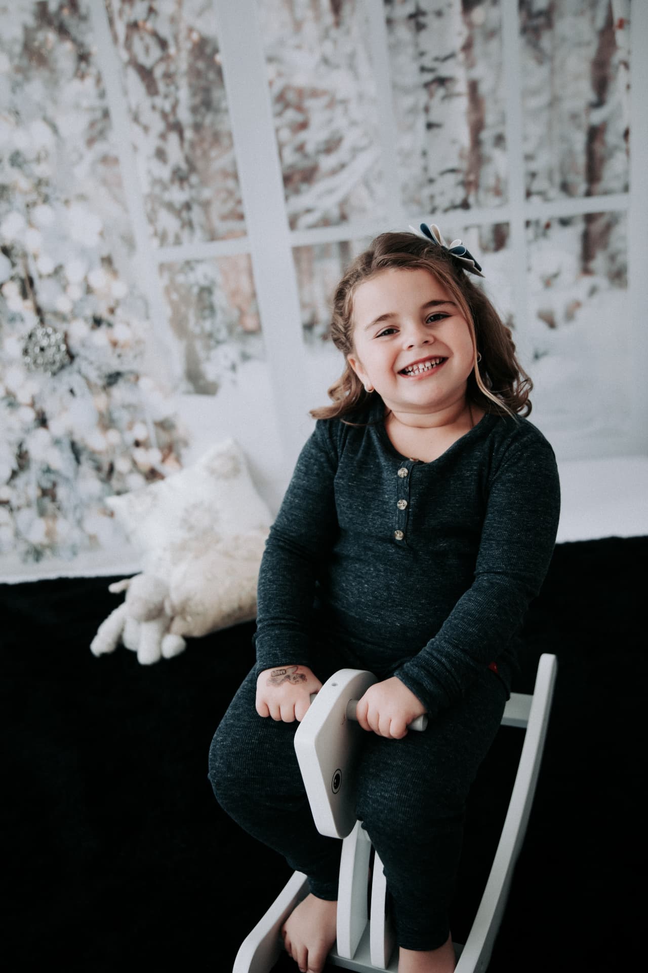 Child smiling in a snowy white winter studio set