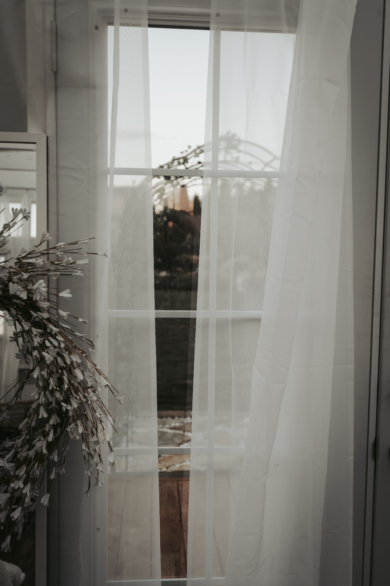 Sheer curtains and window overlooking the garden arbor
