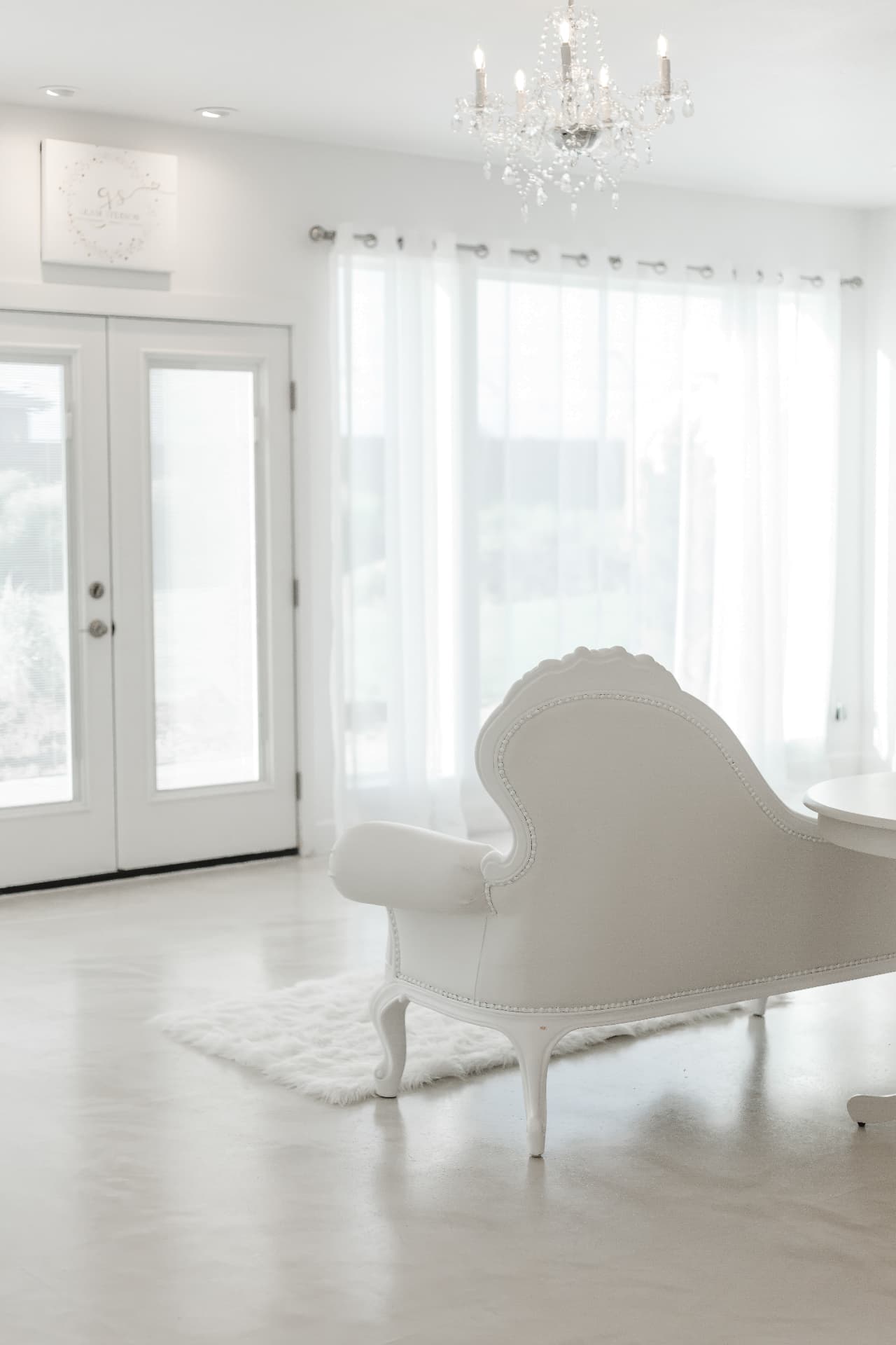 Victorian white chaise beneath a crystal chandelier at Glam Studios