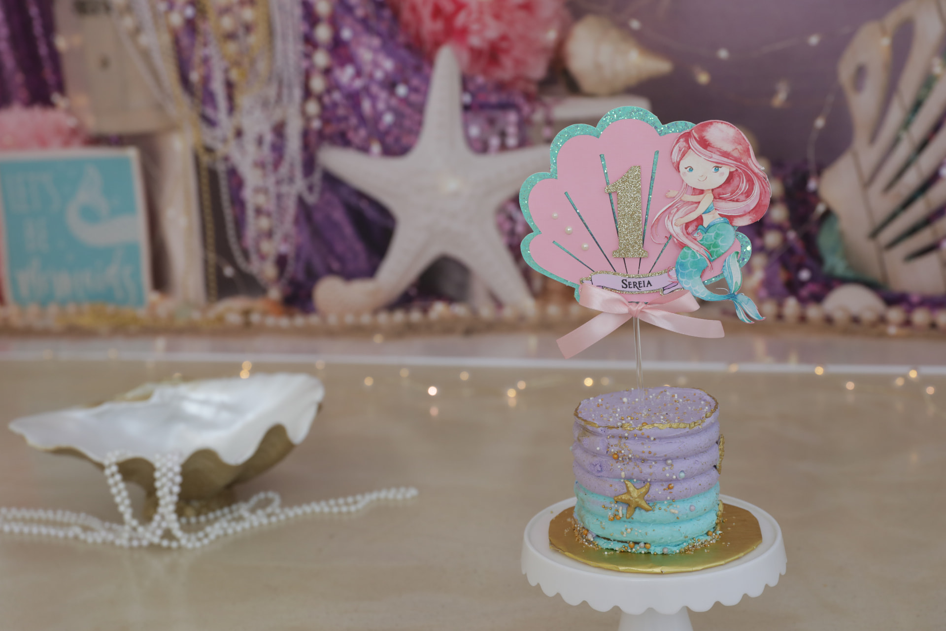 Under-the-sea mermaid cake smash set with shells, pearls and a pastel cake