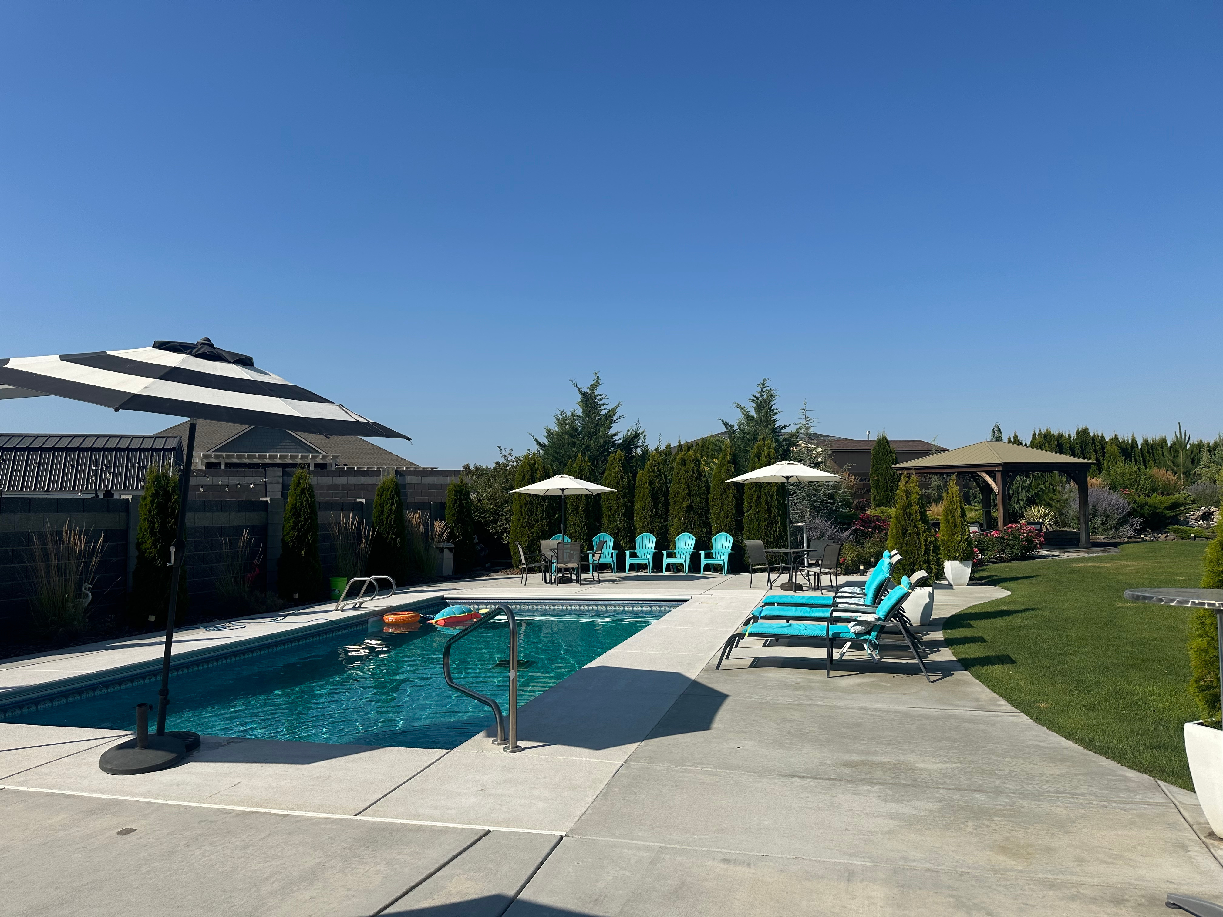 Poolside seating and fire pit under a clear blue sky